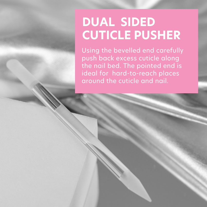 Product photo of cuticle pusher laying flat on a clear table